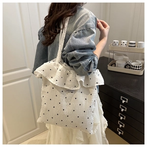 Close-up of the ruffled edge and floral pattern on a white mesh shoulder tote bag