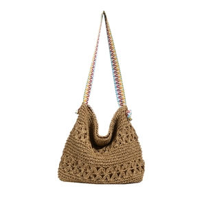 Brown woven straw tote bag with colorful geometric patterned shoulder strap on white background