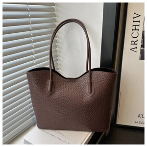 Detailed view of dark brown tote bag featuring premium woven texture and sleek shoulder straps