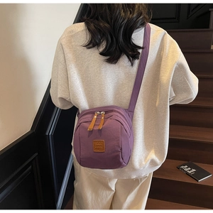 Vue détaillée arrière du sac bandoulière en nylon violet avec double fermeture éclair