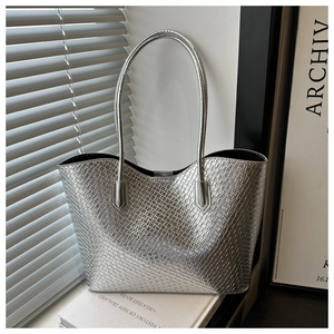 Detail of silver crocodile pattern tote bag featuring metallic texture and double straps
