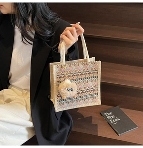 Close-up of ethnic woven pattern on beige tote bag with cotton rope handle and plush charm