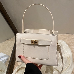 Minimalist beige crossbody bag with gold twist lock and rounded top handle for women