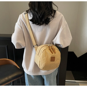 Détail du sac bandoulière en nylon kaki avec double fermeture éclair et sangle