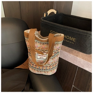 Détail du sac cabas tissé avec motifs ethniques et poignées en tissu marron