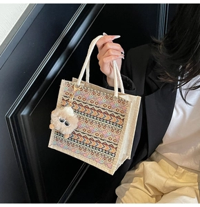 Close-up of ethnic tote bag with woven patterns, cotton rope handles and plush charm