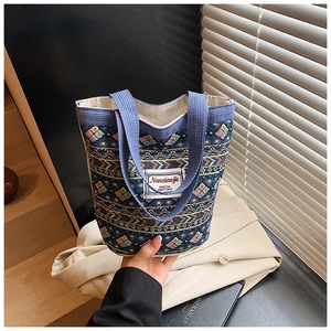 Détail du tissage ethnique bleu et de la large anse en ruban de ce sac à main boutique