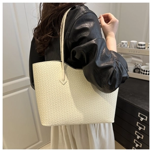 Detail of white woven tote bag texture and long shoulder strap on model