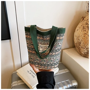 Gros plan du sac cabas tissé bohème avec motifs géométriques et poignées de transport solides