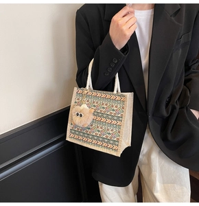 Close-up of ethnic style woven tote bag with orange geometric pattern and rope handle