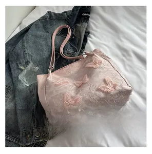 Detail shot of a light pink lace shoulder bag featuring 3D butterfly floral appliqués