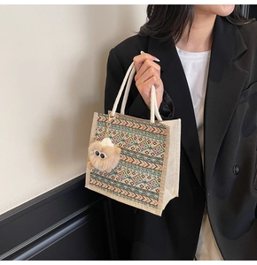 Ethnic canvas tote bag with braided handles and colorful geometric patterns with plush charm