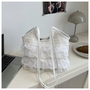 Close-up of white layered lace tote bag with delicate ruffles and soft texture details
