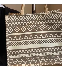 Detail of canvas tote bag featuring brown geometric ethnic patterns and woven texture