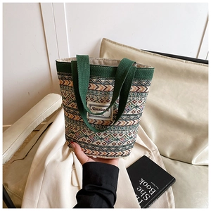 Détail du sac cabas tissé géométrique multicolore avec poignées vertes et étiquette