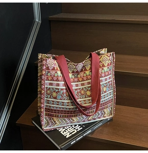 Detail of bohemian tote bag with colorful geometric patterns on wooden stairs