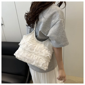 Detail of multi-layer white lace ruffles and fine mesh texture on a tote bag