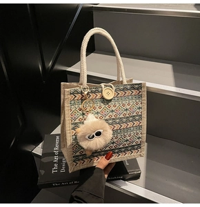 Detailed view of ethnic woven tote bag featuring geometric patterns and wooden button