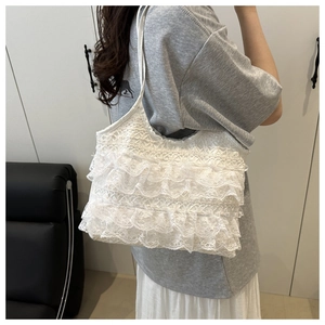 Detail shot of white layered lace pleated tote bag with lightweight ruffle texture