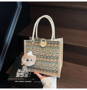 Ethnic woven tote bag with colorful geometric patterns and a plush monster charm