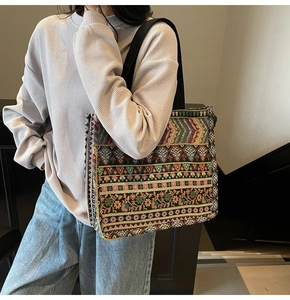 Detailed close-up of bohemian woven tote bag featuring colorful geometric floral embroidery