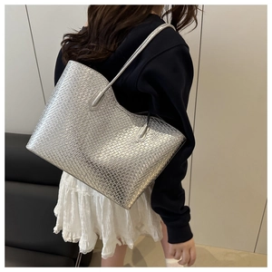 Detail of silver woven tote bag with square texture and sleek metallic finish