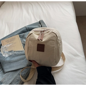 Gros plan sur la texture en nylon beige avec étiquette en cuir sur un sac à dos