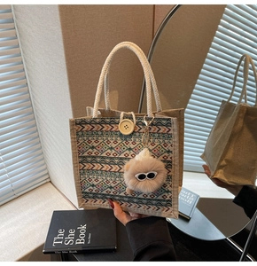 Detail of bohemian tote bag with geometric woven patterns and a plush charm