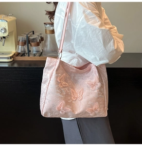 Detailed shot of pink tote bag featuring 3D butterfly appliques and lace texture finish