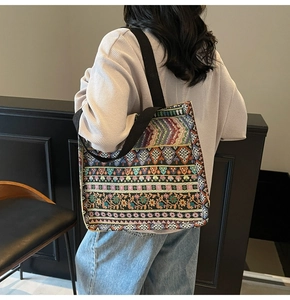 Detail of bohemian tote bag featuring colorful ethnic weaving and a wide black strap