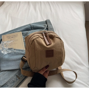 Détail de sac à dos en nylon kaki avec logo en cuir et fermetures éclair doubles