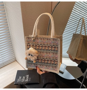 Detail of retro ethnic woven tote bag with cotton rope handles and plush monster charm