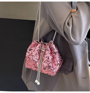 Dettaglio borsa a secchiello rosa con paillettes, catena argento e ciondoli di perle