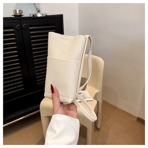 Detailansicht der cremefarbenen vertikalen Handytasche mit litchi-narben und Umhängeriemen