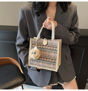 Macro view of woven tote bag featuring ethnic pattern webbing and cotton rope handles