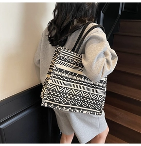 Detail of large canvas tote bag with black and white geometric ethnic pattern and black handles