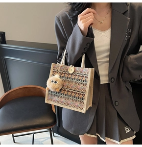 Ethnic knit tote bag with geometric patterns, wood button, and plush charm detail