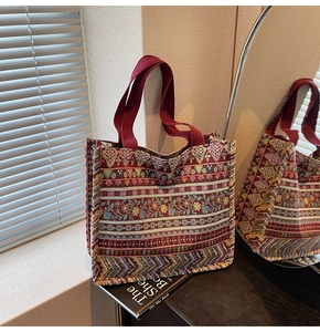 Detail of bohemian jacquard tote bag featuring colorful geometric patterns and red handles