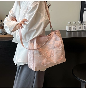 Pink tote bag detail with textured fabric and elegant butterfly floral embroidery
