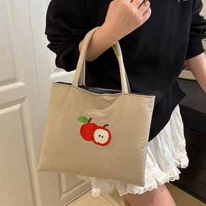 Minimalist beige canvas tote bag with red apple embroidery for stylish commuting women