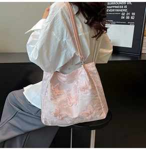 Detail of pink floral jacquard tote bag featuring 3D butterfly appliqués and slim straps