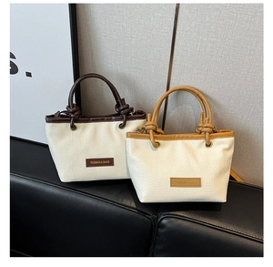 Close-up of woven straw bucket bags with leather trim and knotted handle detail