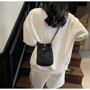 Rear view of black nylon drawstring crossbody phone bag with woven black and white strap