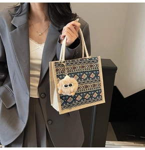 Ethnic tote bag detail with woven geometric patterns and fluffy plush pendant