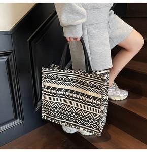 Detail of large canvas tote bag featuring ethnic geometric patterns and black handles