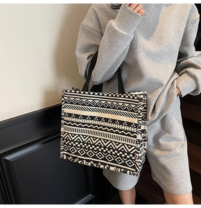 Detail of bohemian canvas tote bag with black geometric patterns shown on a model