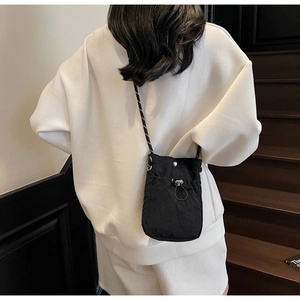 Detailed back view of a compact black nylon crossbody phone bag with drawstring closure