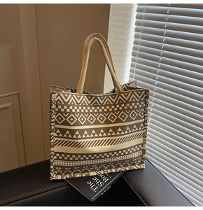 Detailed macro view of geometric ethnic patterns and thick woven handles on canvas tote bag