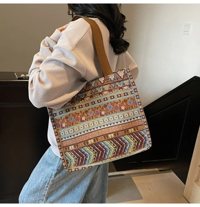 Detailed close-up of bohemian jacquard patterns on a large ethnic tote bag worn on shoulder