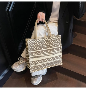 Detailed macro view of woven geometric texture on a beige and brown canvas tote bag